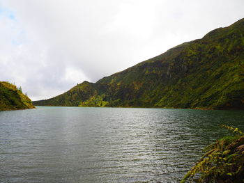 Scenic view of lake by mountain against sky