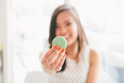 Close-up of woman holding pistachio macaroon