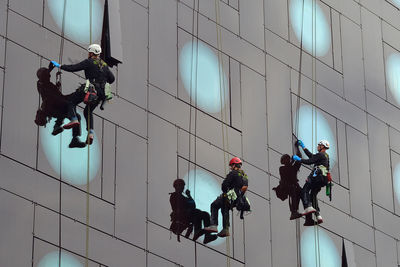 Low angle view of people working on building