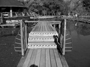 Footbridge over lake against trees