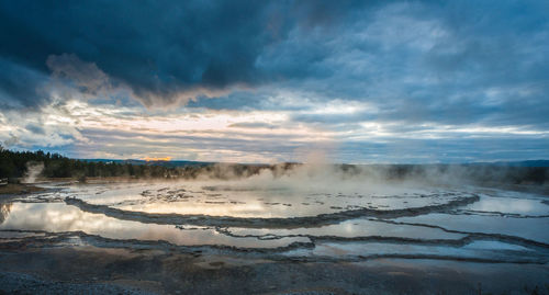 Scenic view of hot spring against cloudy sky