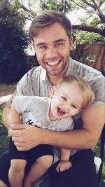 Portrait of father and daughter sitting outdoors