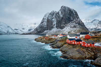 Scenic view of sea and snowcapped mountains against sky