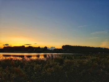 Scenic shot of calm countryside lake at sunset