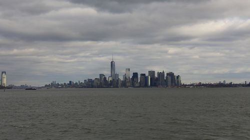 Buildings in city against cloudy sky