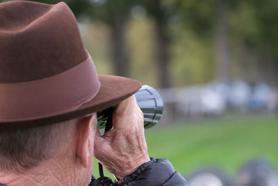 Rear view of horse racing spectator with binoculars