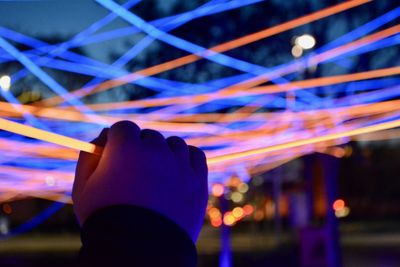 Midsection of person holding illuminated lighting equipment at night