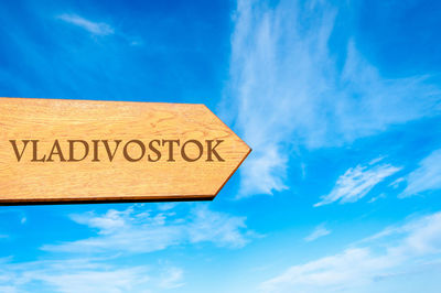 Low angle view of information sign against blue sky