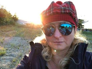 Portrait of young woman wearing sunglasses against sky