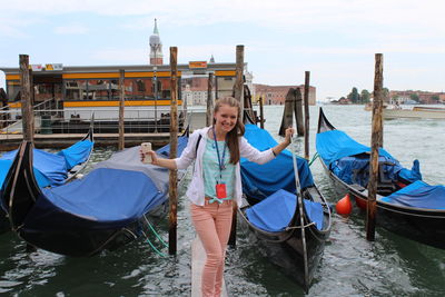 Portrait of woman standing on boat in canal against sky venice 