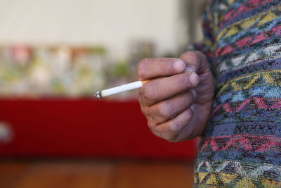 Close-up of hand holding cigarette