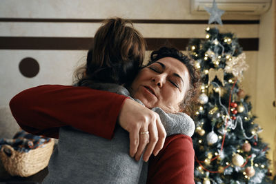 Midsection of couple with christmas tree