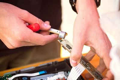 Midsection of man repairing computer part