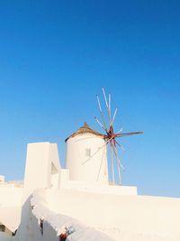 Low angle view of windmill against clear blue sky