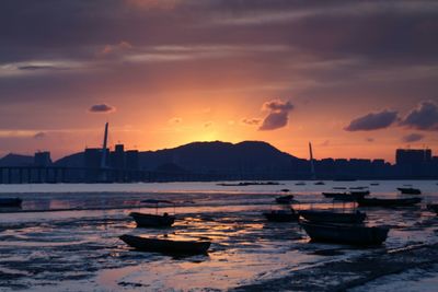 Boats in sea at sunset