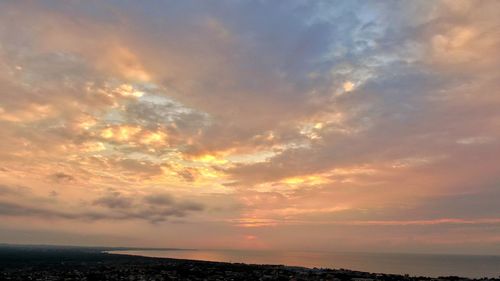Scenic view of sea against dramatic sky during sunset