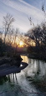 Scenic view of river against sky at sunset