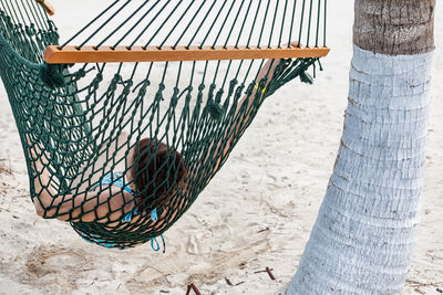 Woman lying on hammock at beach