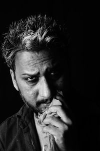 Close-up portrait of man against black background