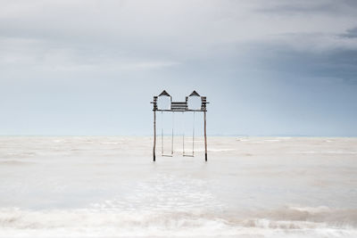 Lifeguard hut on beach against sky