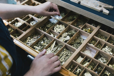 Female craftsperson opening drawer with jewelry making materials