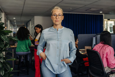 Portrait of confident female entrepreneur standing at work place