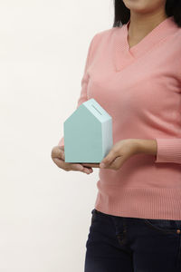 Midsection of woman holding book against white background