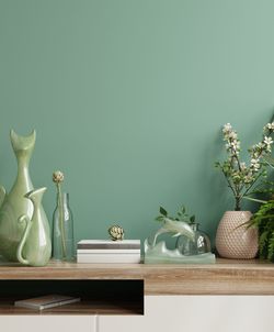 Flower vase on table against wall at home