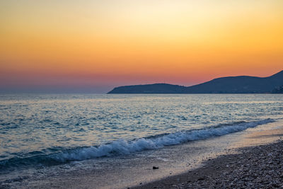 Scenic view of sea against orange sky