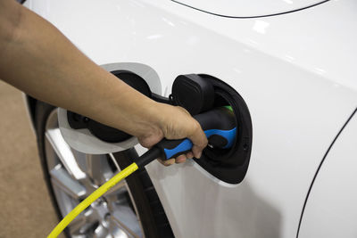 Close-up of hand charging electric car