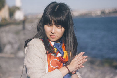 Beautiful woman with hands clasped by sea