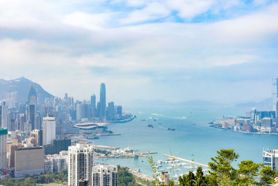 Modern buildings by bay against sky