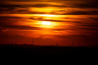 Scenic view of silhouette landscape against orange sky