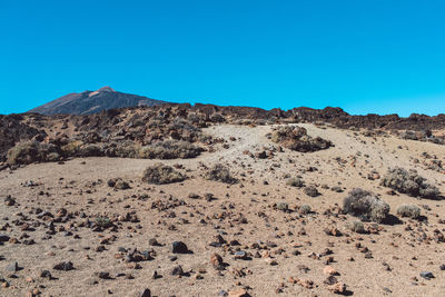 Scenic view of desert against clear blue sky