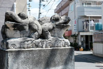 Close-up of statue against building in city