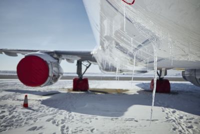 Selective focus on icicles from airplane in frosty day. grounded plane at snowy airport. 