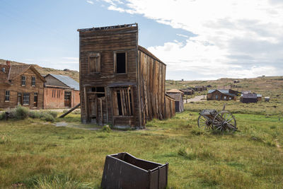 Old west abandoned house in ghost town on field against sky