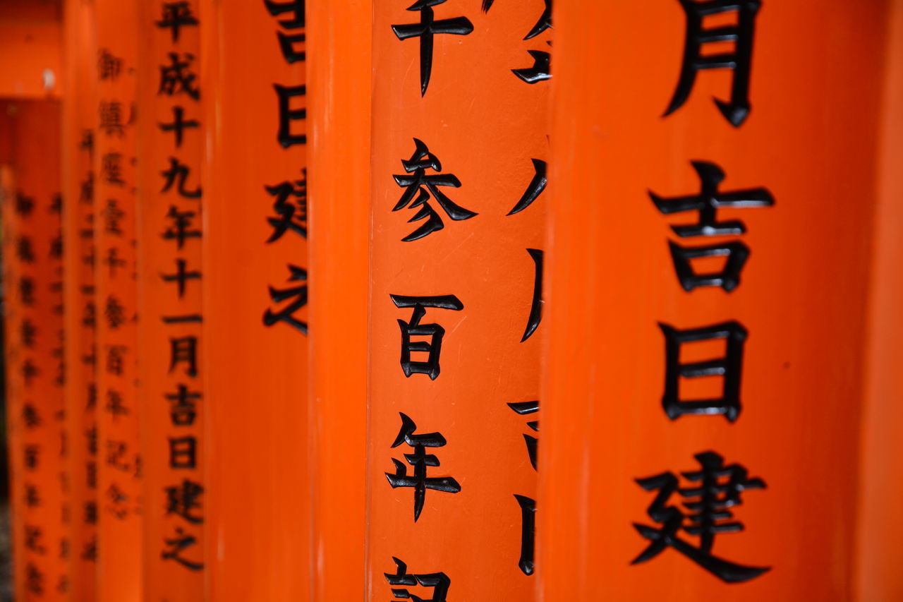 orange color, no people, selective focus, in a row, spirituality, close-up, text, communication, day, religion, backgrounds, outdoors