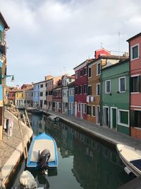 View of boats in canal along buildings