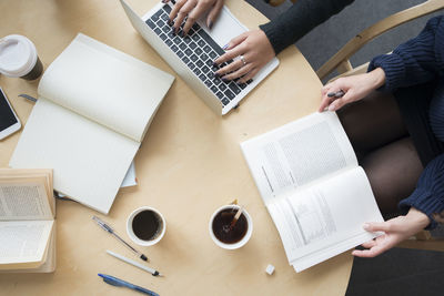 High angle view of people sitting at table in library