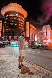 Full length of man standing on street at night