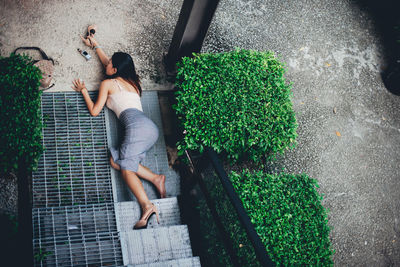 High angle view of woman standing on potted plant