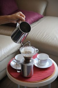 Midsection of woman holding coffee on table