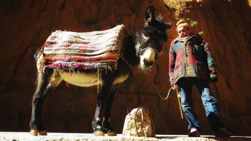 Midsection of person standing by wall