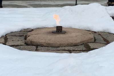 Stone wall by snow covered land