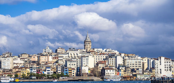 Buildings in city against cloudy sky in istanbul