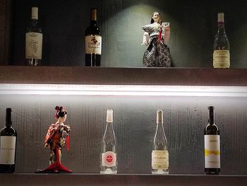 Sculpture of bottles on shelf at home