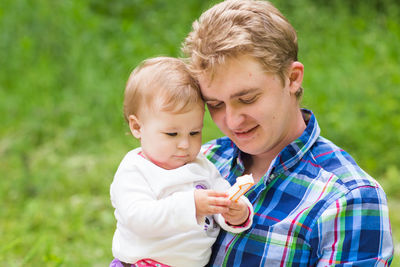 Portrait of boy holding baby outdoors