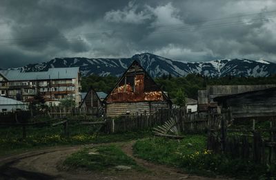 Old building by field against sky