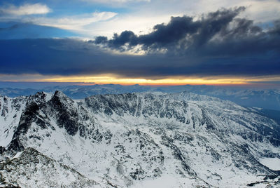 Scenic view of snowcapped mountains against sky during sunset